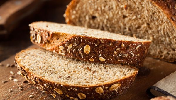 Two slices of whole wheat bread with grains.