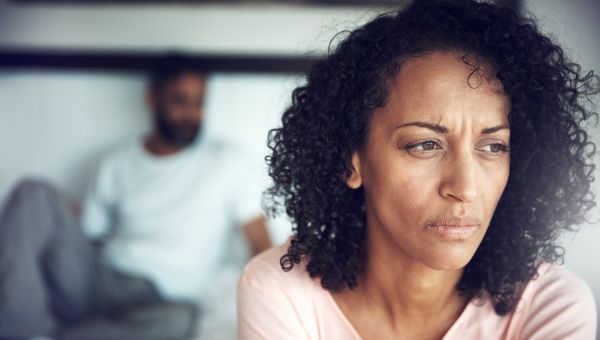 woman on bed looking concerned 