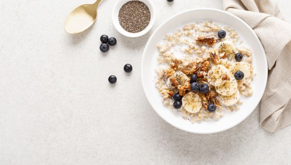 a bowl of oatmeal garnished with banana, walnuts, blueberries and chia seeds