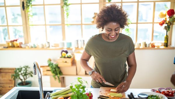 woman cutting vegetables in kitchen