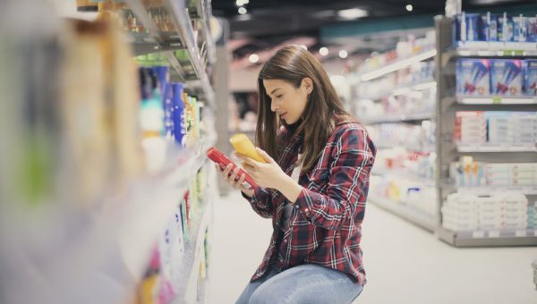 woman choosing sunscreen at store