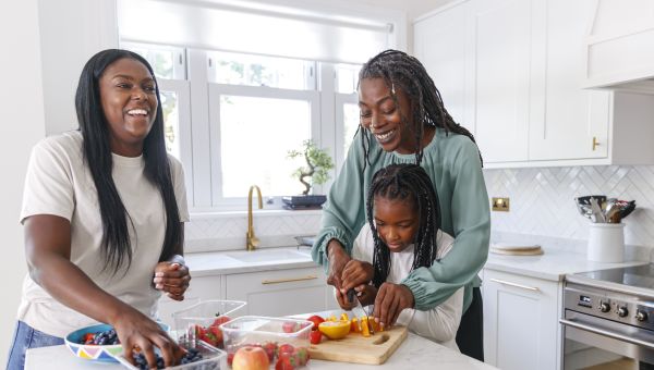 a multi-generational Black family—a mother, daughter, and grandmother—prepare a healthy breakfast in a kitchen