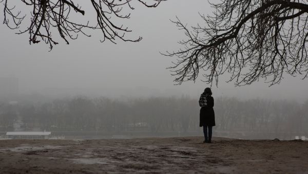 A woman standing alone on a gloomy day