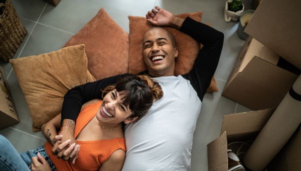 young couple lying on the floor together laughing 