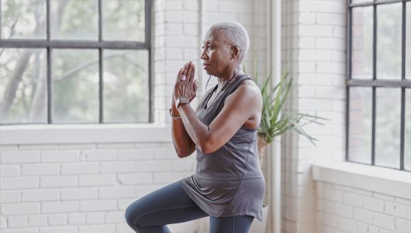 older Black woman tree yoga pose