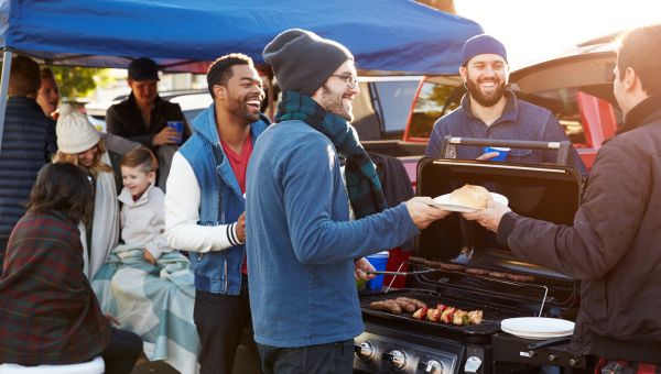 a group of friends enjoy each other's company at a football game tailgate party