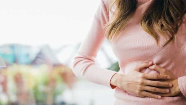 woman clutching her abdomen from gas pain