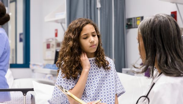 girl with stiff neck in a hospital gown