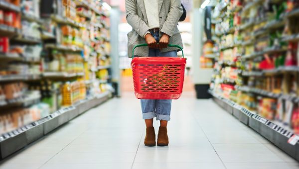 woman holding shopping basket in grocery store