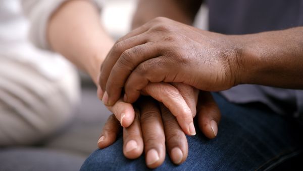 Two people holding hands and talking with a therapist