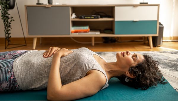 woman lying on floor meditating