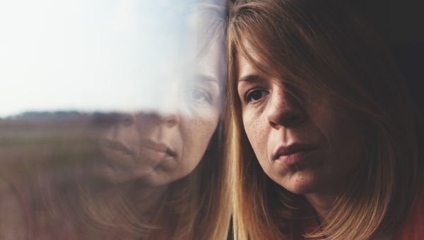 woman with brain fog looking out window