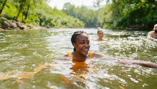 someone swimming in a river in nature with friends