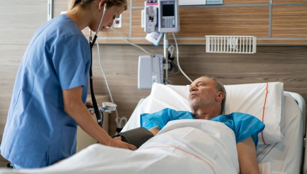 nurse comforting patient in hospital bed