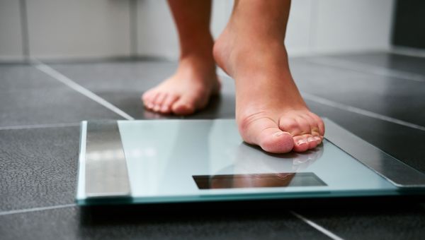 Woman stepping onto weight scale