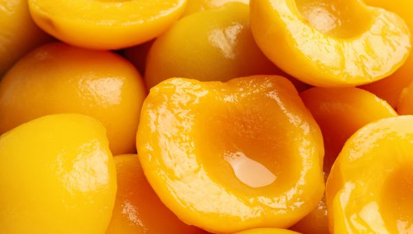 a closeup shot of canned peaches, which contain added sugar