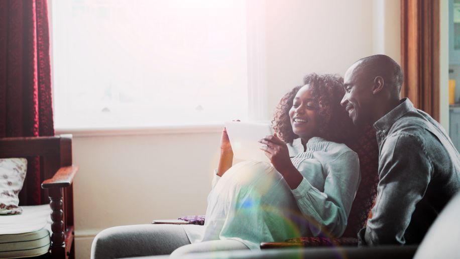 two people looking at an ultrasound together, one of whom is pregnant