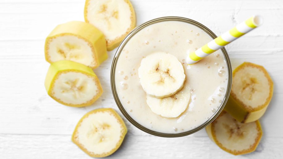 banana smoothie in a glass with a straw