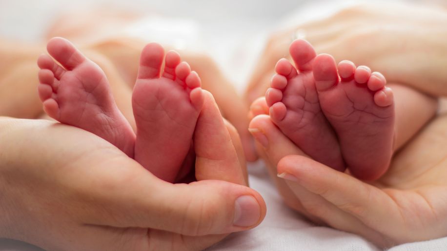 Two pairs of infant feet.