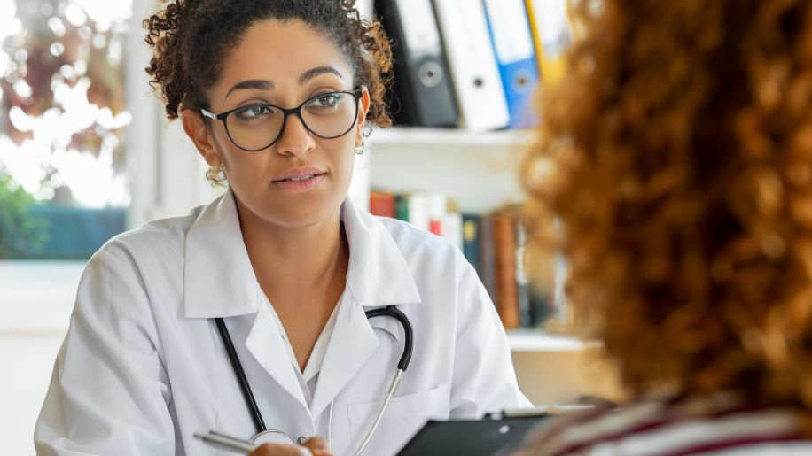 a young healthcare provider speaks with someone about a diagnosis