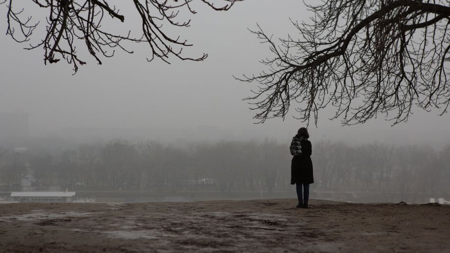 A woman standing alone on a gloomy day