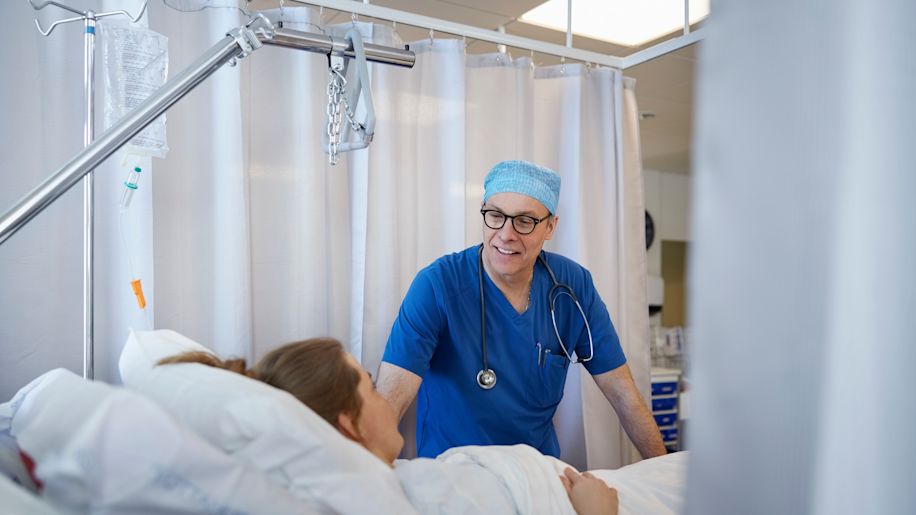 surgeon speaks to patient in recovery