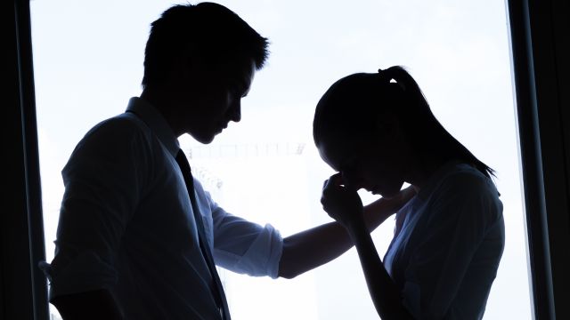 man consulting woman in silhouette against window