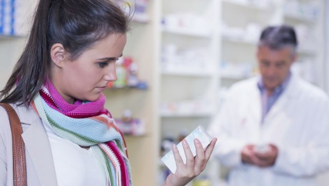 Customer holding a drug box in the pharmacy