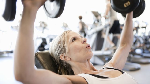 woman lifting free weights in fitness gym
