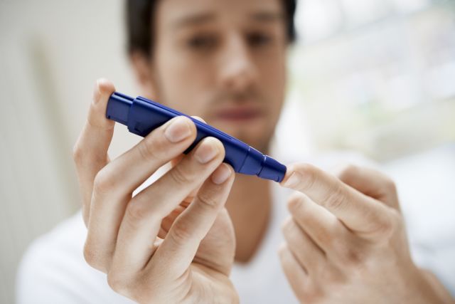 A man tests his blood with a finger prick, as he learns how to control and treat his type 2 diabetes with diet and exercise.