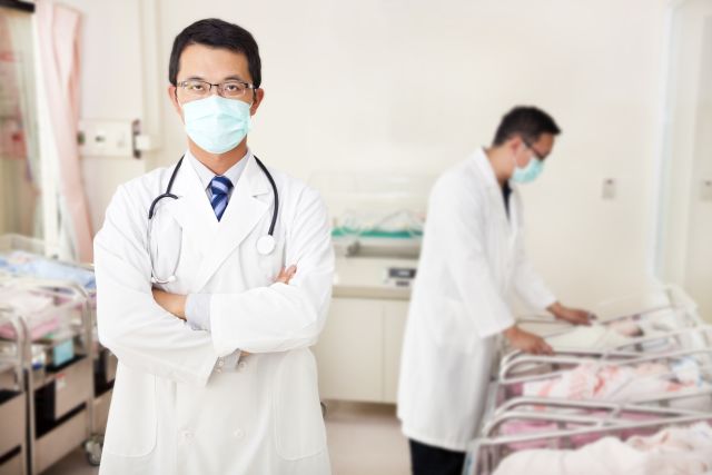 doctor and assistant care fake newborn fake baby  in baby room at hospital