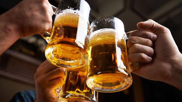 Three friends clink beer steins together in celebration—but will they need hangover help in the morning? 