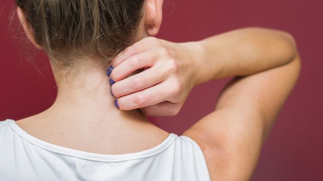 woman scratching her neck