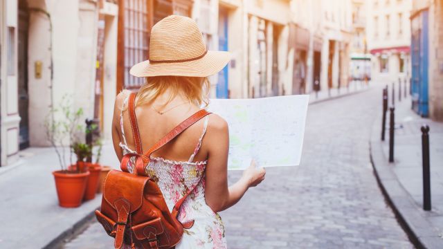 A woman who is traveling with IBS diarrhea checks a map. She knows how to travel with IBS.