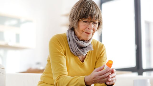 Senior woman examining pill bottle