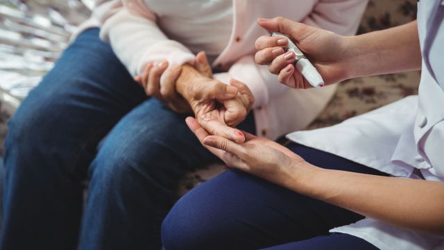 Nurse helping senior woman with diabetes