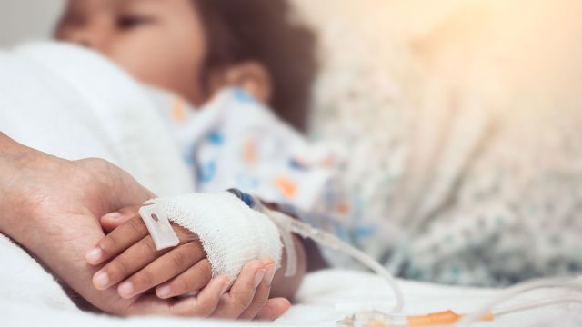 Mother holding her child's hand in hospital