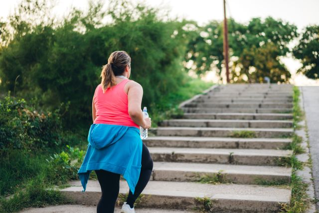 Obese woman climbing stairs outdoors