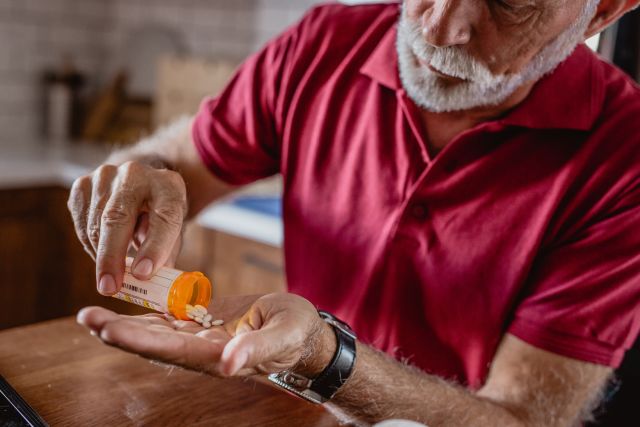 older man taking medication