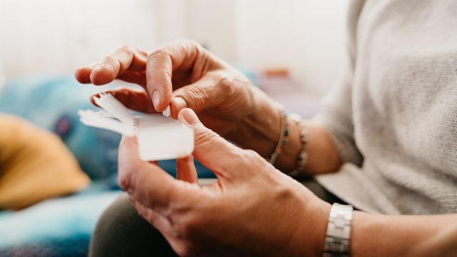 Woman taking meds from a pill dispenser