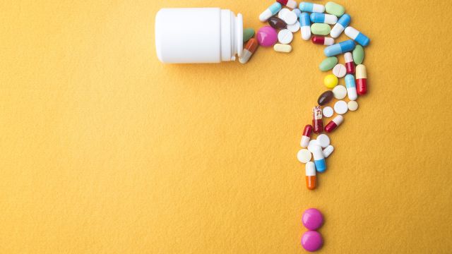 Various pills in shape of a question mark.