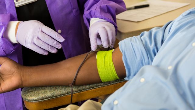 A doctor draws blood from a patient. The patient is getting tested for hep C.