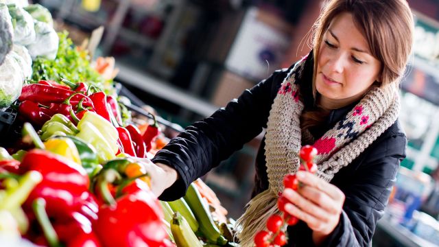 A woman selects healthy foods from a diabetes food list. She plans to cook diabetes friendly food. 