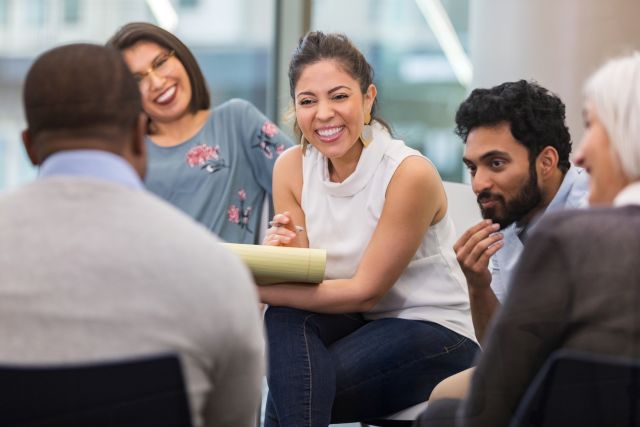members of a group counseling workshop talk and laugh together