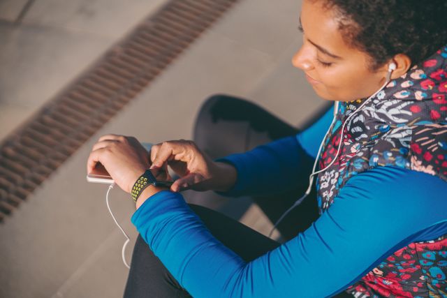 Woman using activity tracker outdoors