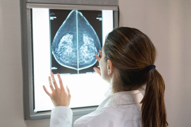 A radiologist looks at an X-ray image of a breast to detect breast cancer