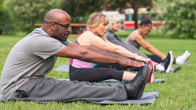 An outdoor exercise class with men and women. Exercise is important to heart health for men and women. 
