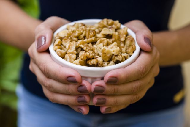 holding a bowl of walnuts