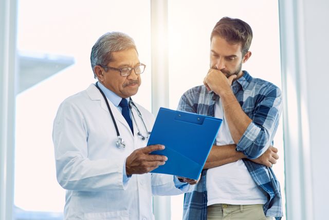 male doctor showing chart to male patient