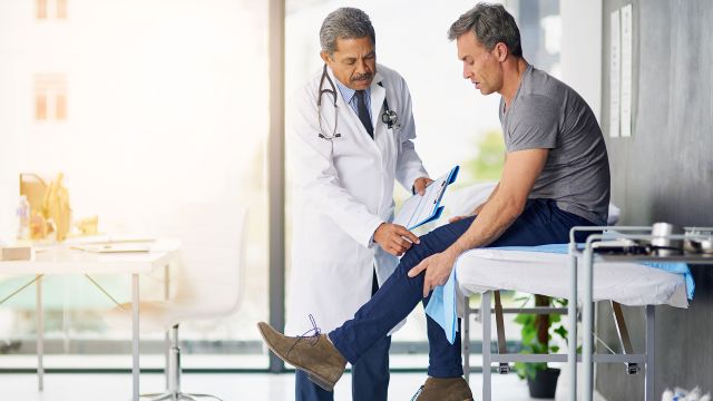 doctor examining patient's knee, knee pain